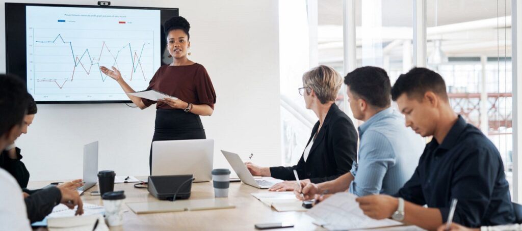 Business woman presenting to colleagues in meeting room 1