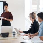 Business woman presenting to colleagues in meeting room 1
