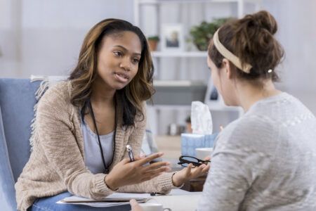 Image of a psychologist talking to a client in a clinical setting