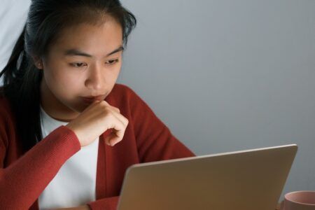Girl working at computer in bedroom