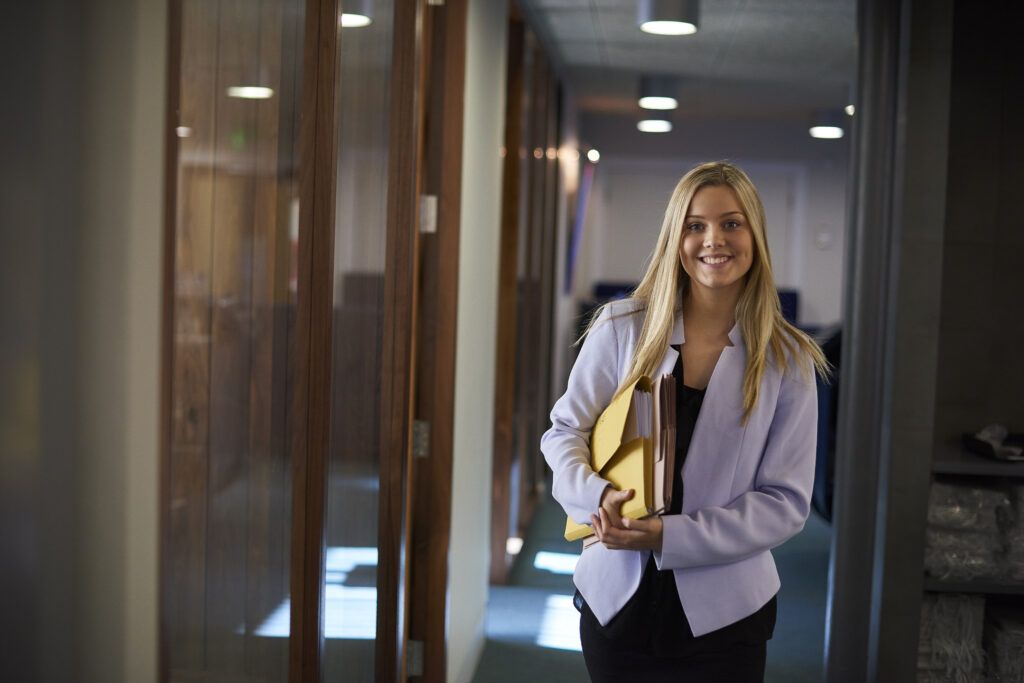 Young business woman smiling at the camera in an office environment