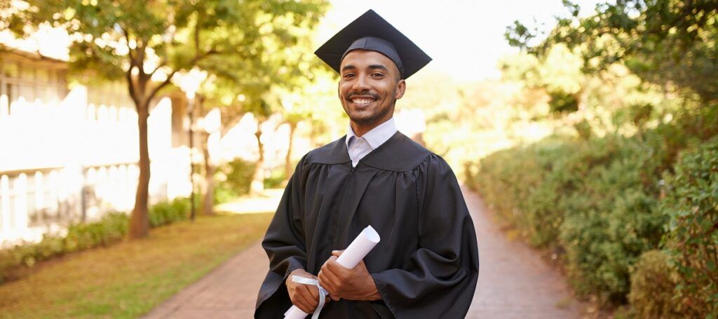 Smiling student graduating wearing cap and gown