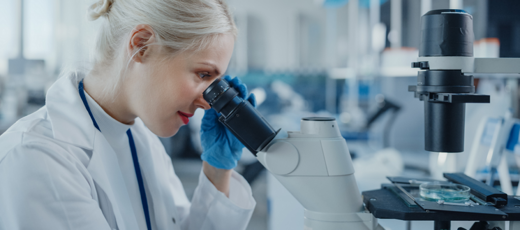 Woman looking through microscope in lab 1