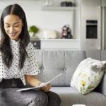 Woman on sofa writing a cover letter